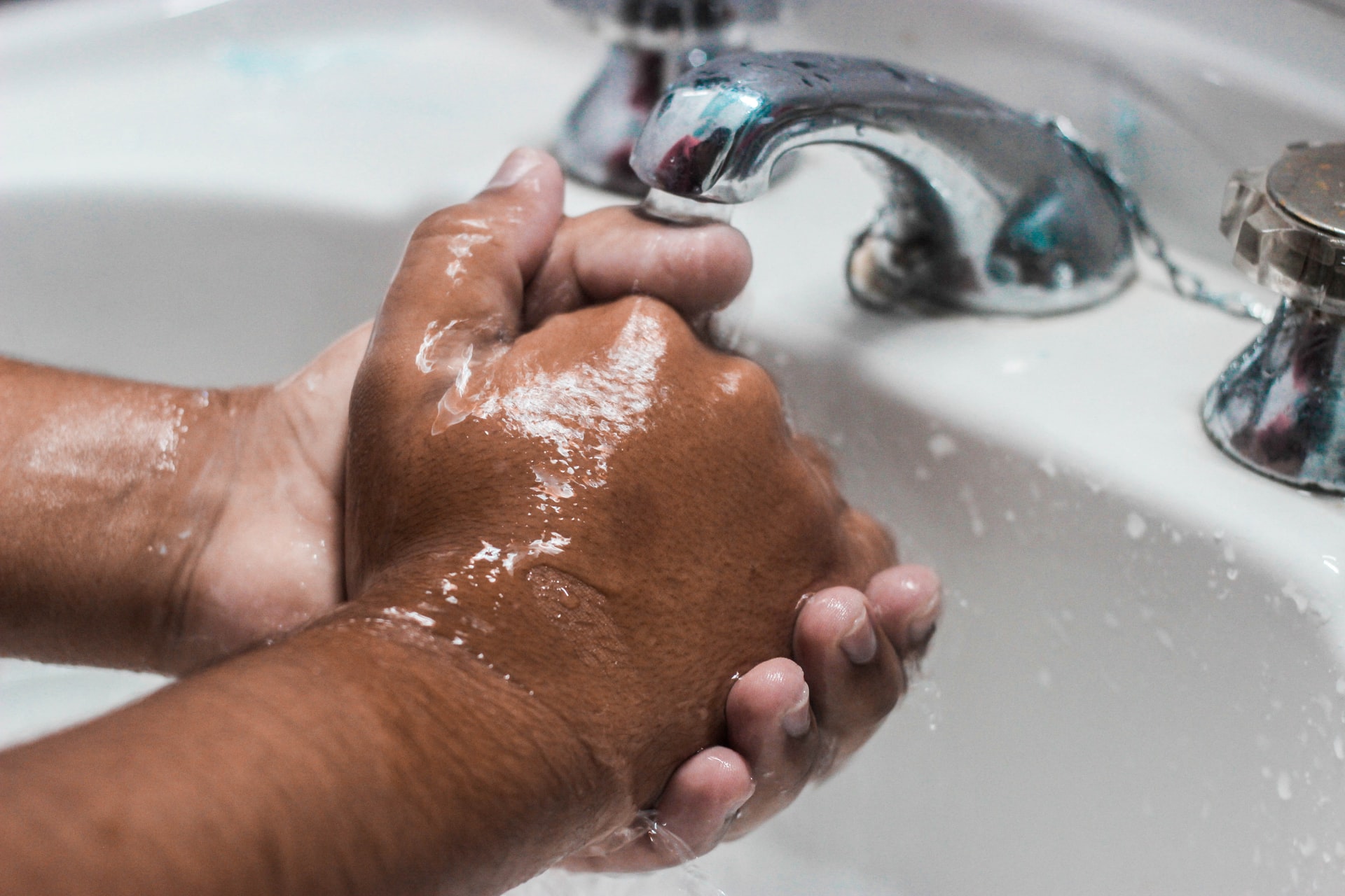 A person washing their hands in a sink