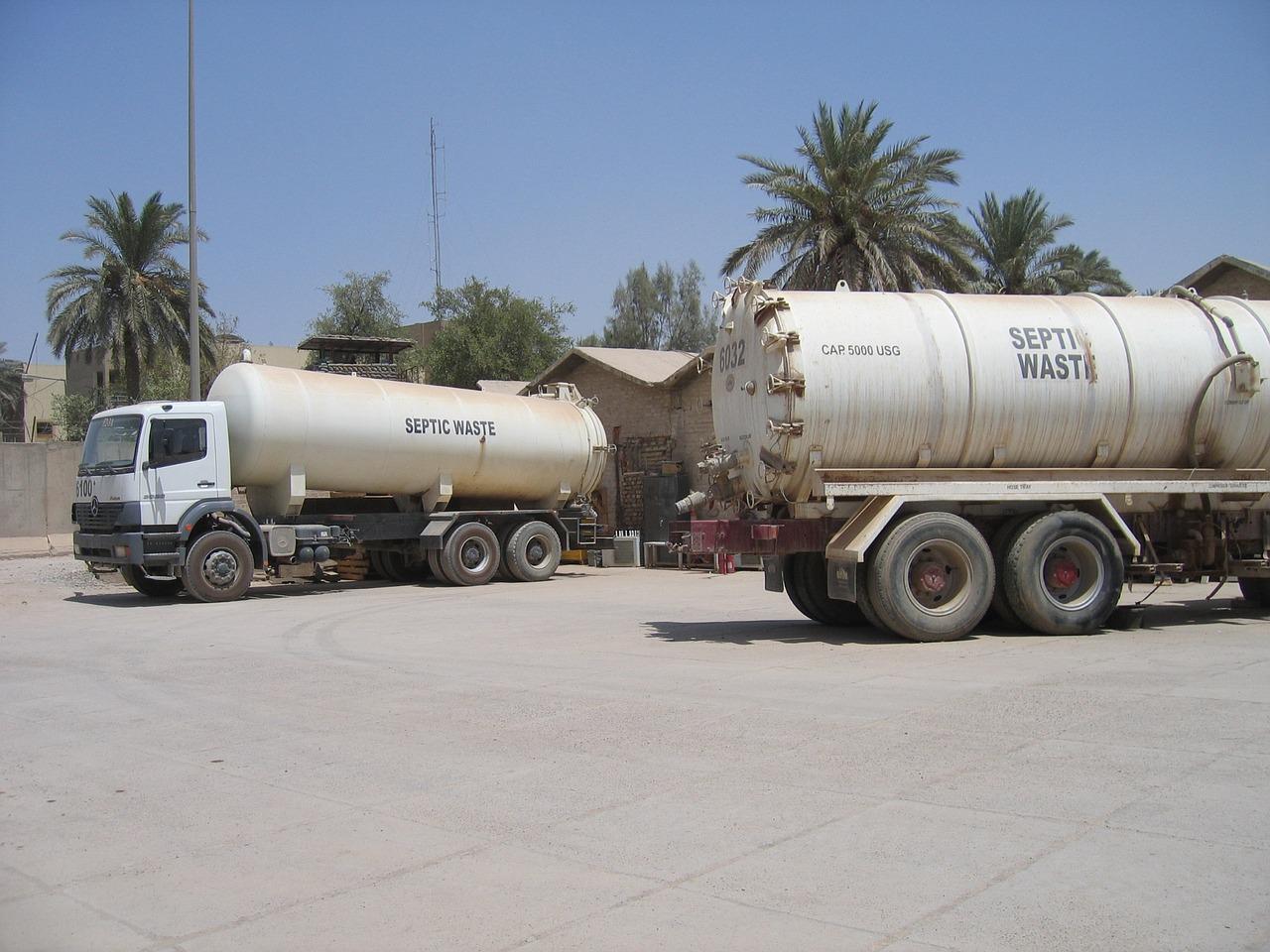 Two septic waste trucks in a parking lot